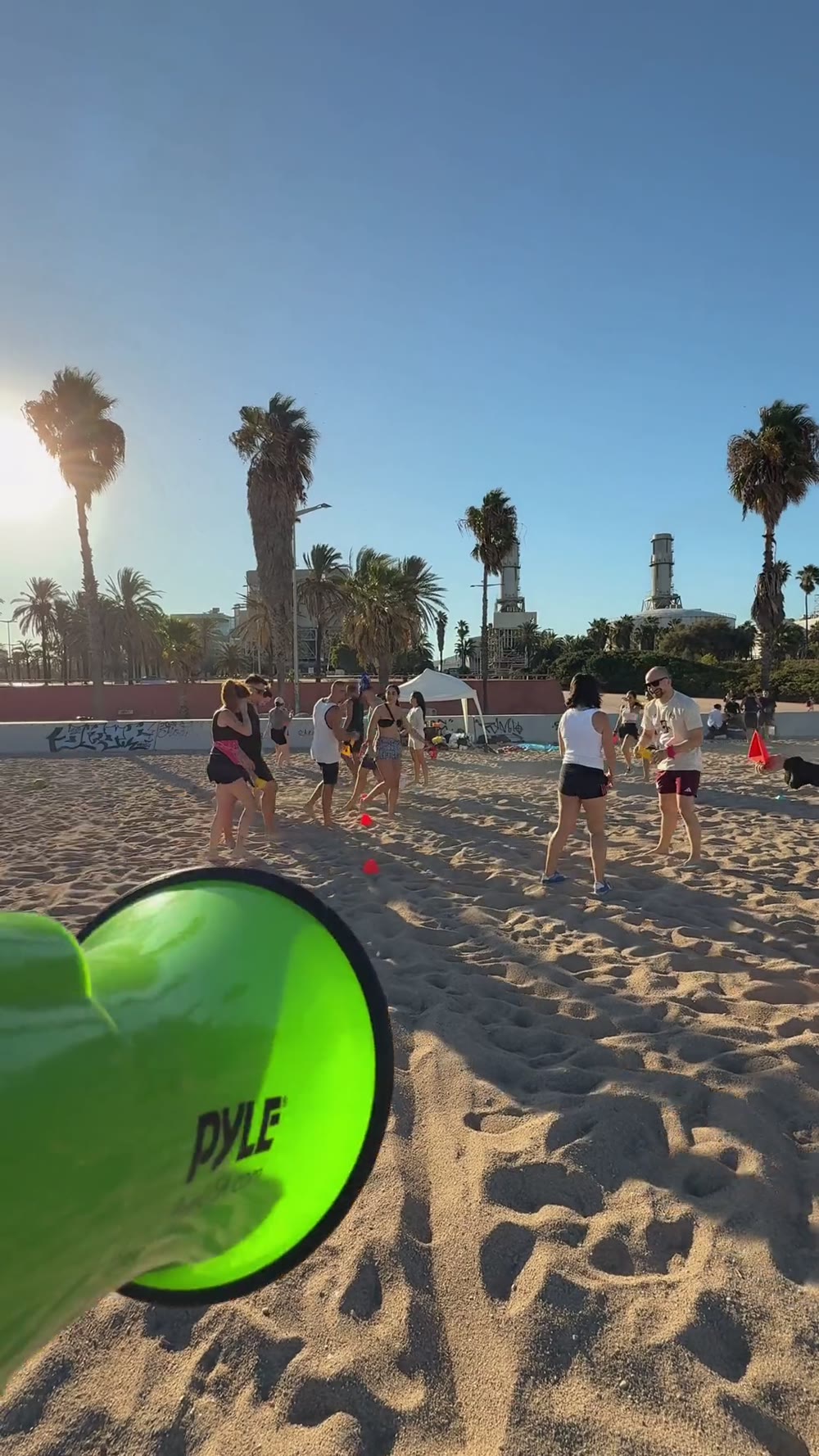 A Barcelona Games team gathered together in a circle at sunset on the beach